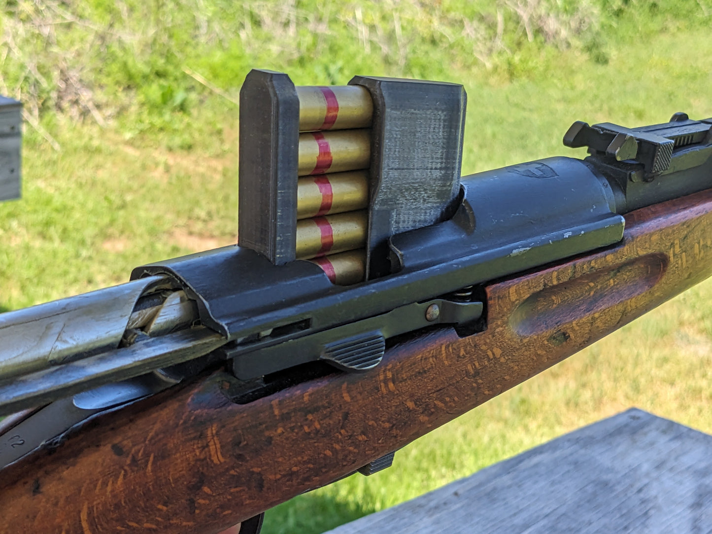 A picture of a 5-round stripper clip inserted into a K31 rifle.